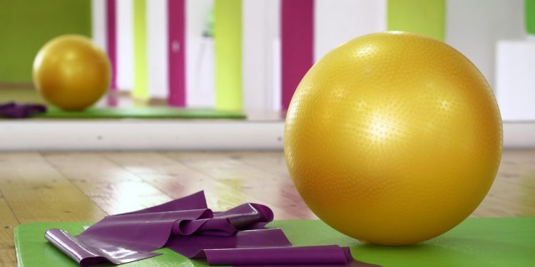 Piłka fitness, mata i taśmy do ćwiczeń w jasnej sali gimnastycznej