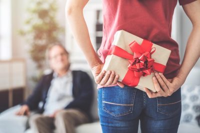 kobieta trzyma prezent za plecami